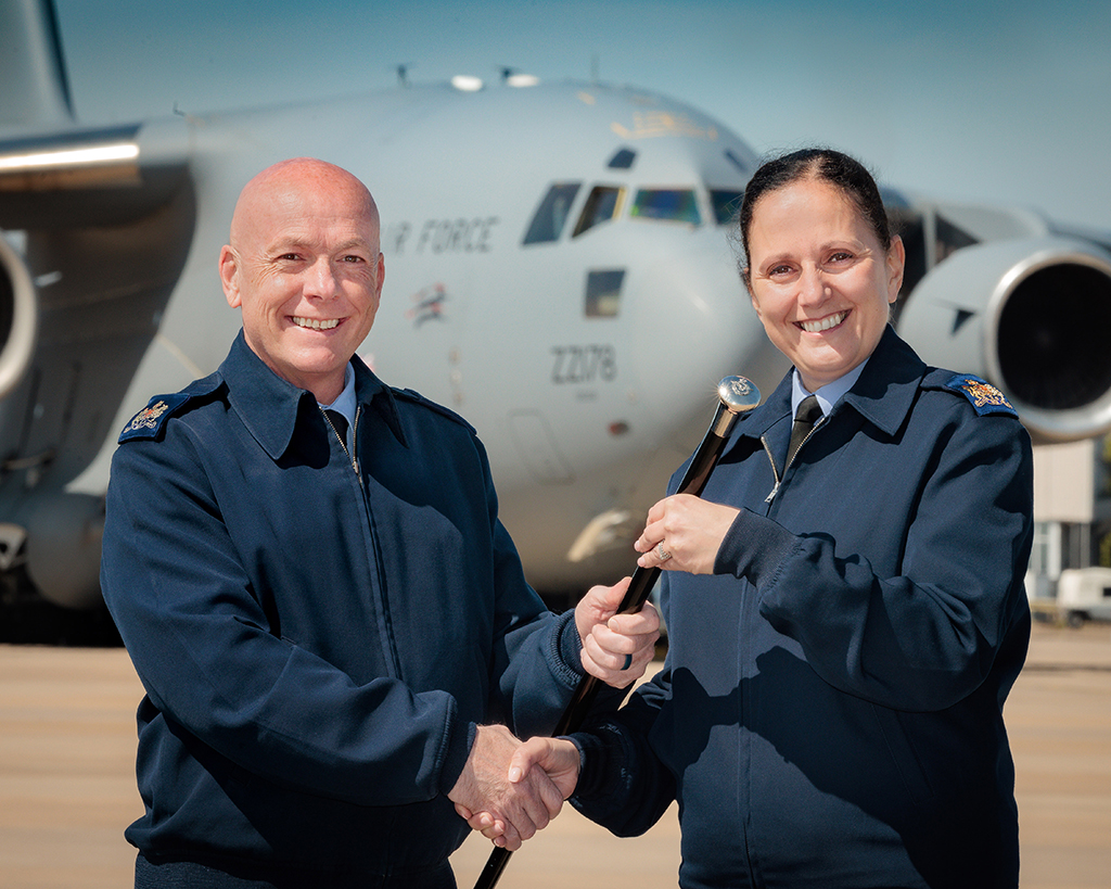 Warrant Officer Tug passes his cane of authority over to Warrant Officer Sim, the incoming Station Warrant Officer.